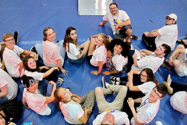 A group of youth and young adults sitting on the floor